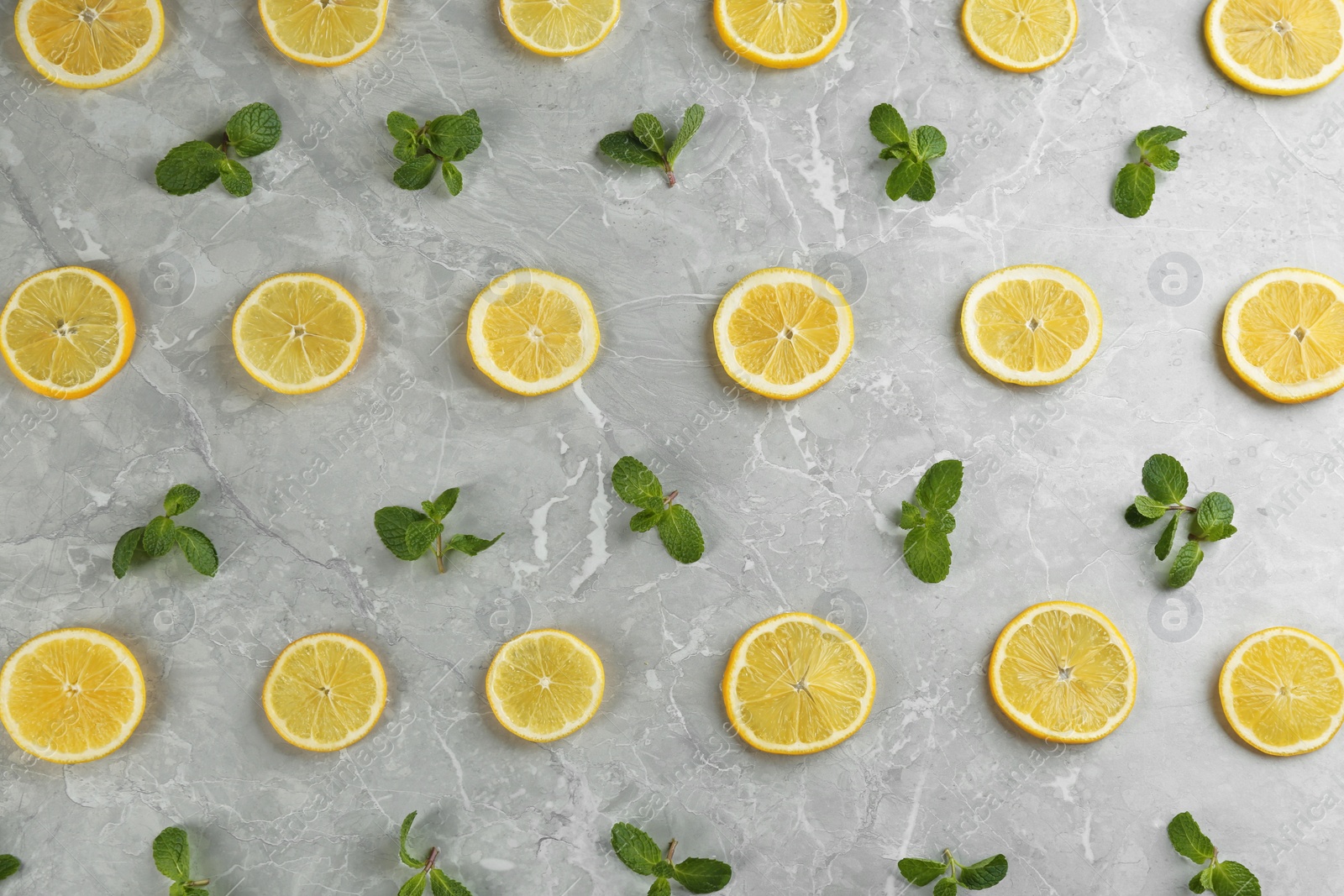 Photo of Lemonade layout with juicy lemon slices and mint on grey marble table, top view