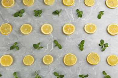 Photo of Lemonade layout with juicy lemon slices and mint on grey marble table, top view