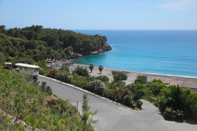 Photo of Picturesque view of sea beach near road and forest