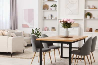 Stylish dining room with cosy furniture and flowers