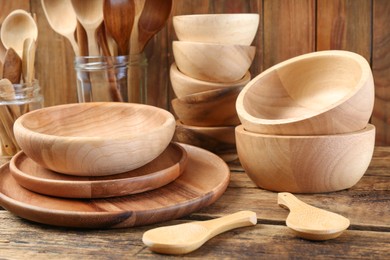 Many different wooden dishware and utensils on table