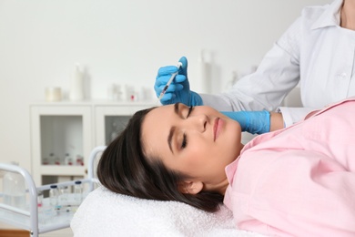 Photo of Young woman with hair loss problem receiving injection in salon