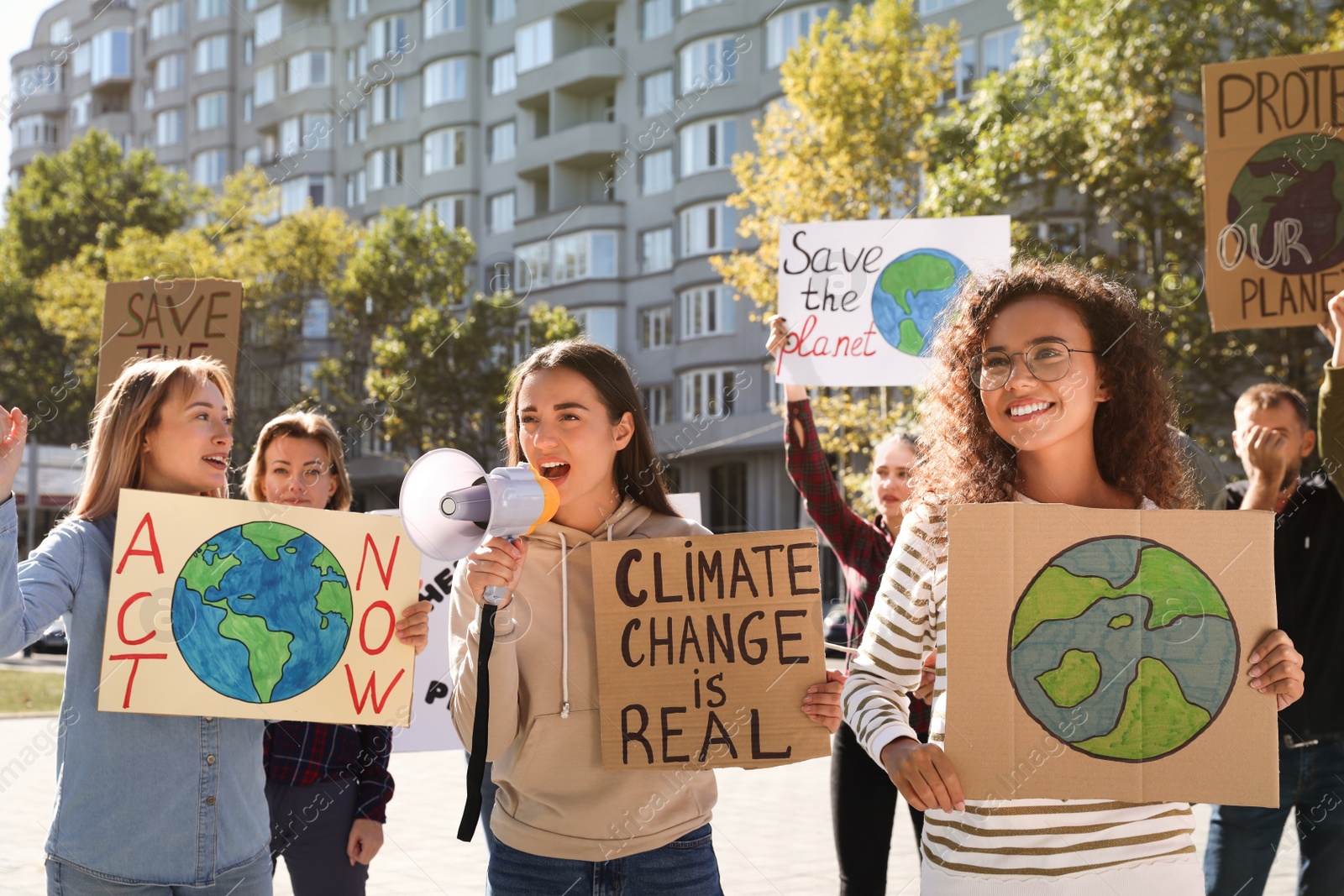 Photo of Group of people with posters protesting against climate change on city street