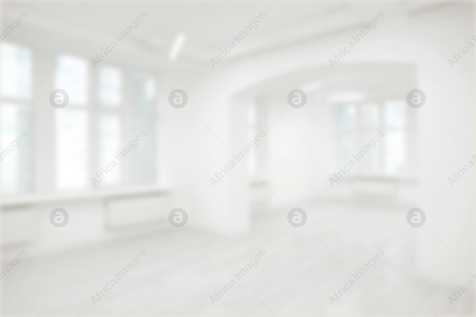 Image of Empty room with white walls and large windows, blurred view