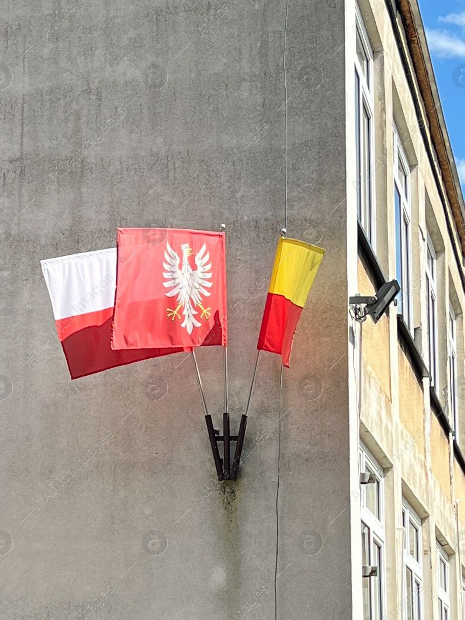 Photo of WARSAW, POLAND - JULY 17, 2022: Building facade with different flags on sunny day