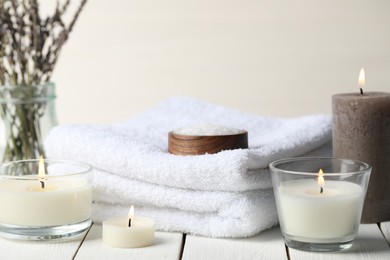 Photo of Beautiful composition with burning candles and different spa products on white wooden table