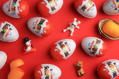 Photo of Sveti Vlas, Bulgaria - June 27, 2023: Kinder Surprise Eggs, plastic containers and toys on red background, flat lay