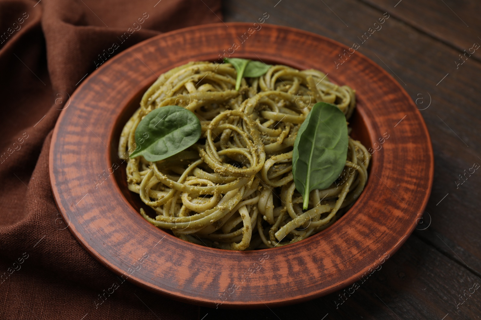 Photo of Tasty pasta with spinach on wooden table