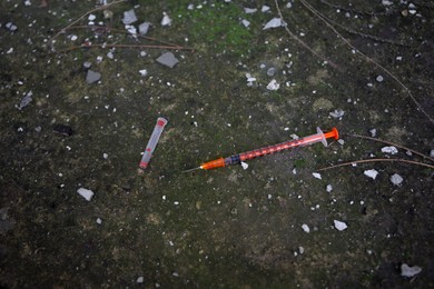 Photo of Empty disposable syringe with needle on street