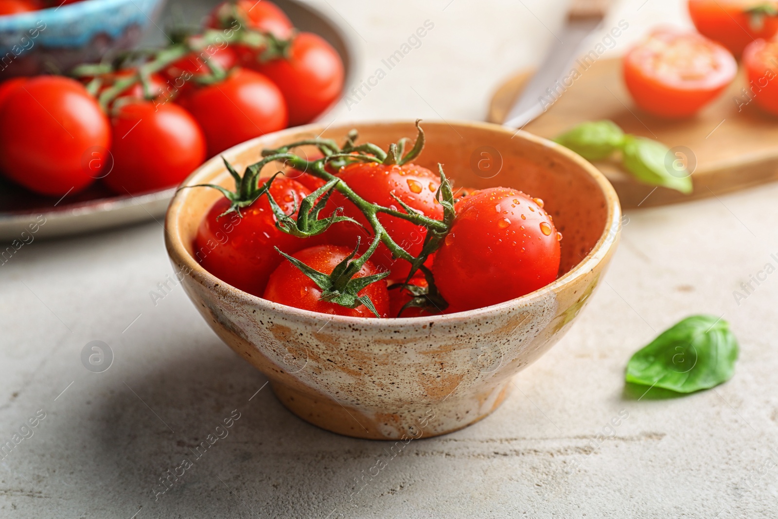 Photo of Bowl with fresh ripe red tomatoes on table