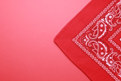 Folded bandana with paisley pattern on red background, top view. Space for text