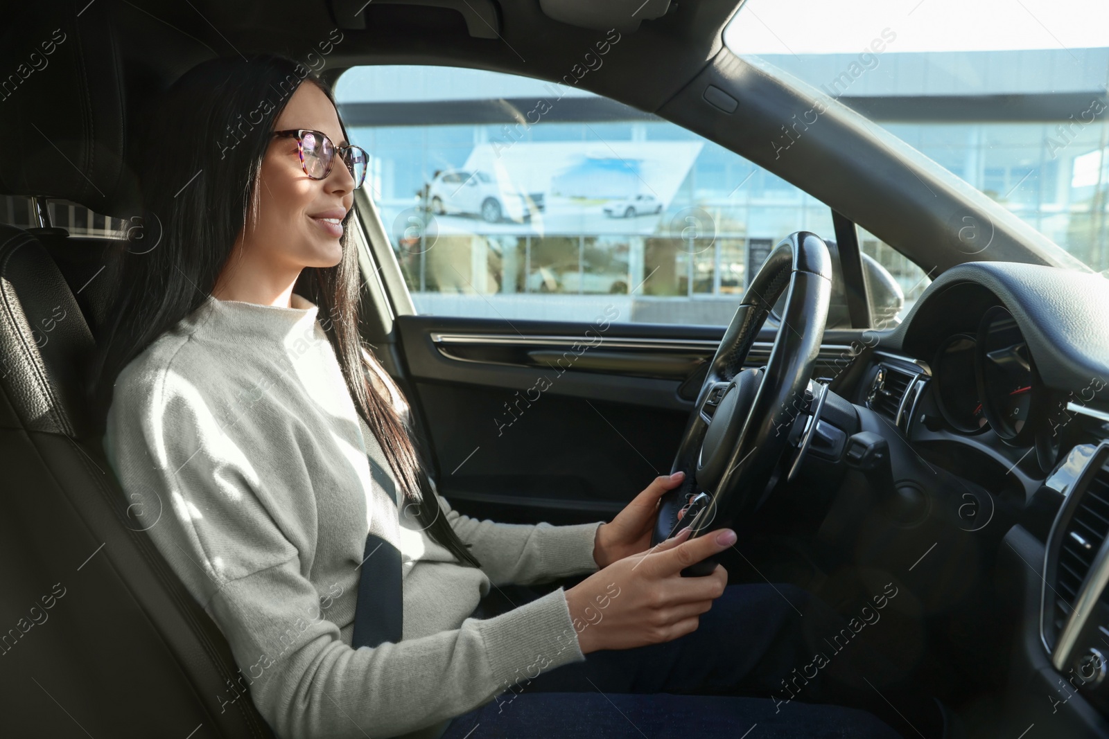 Photo of Beautiful young woman on driver's seat in modern car