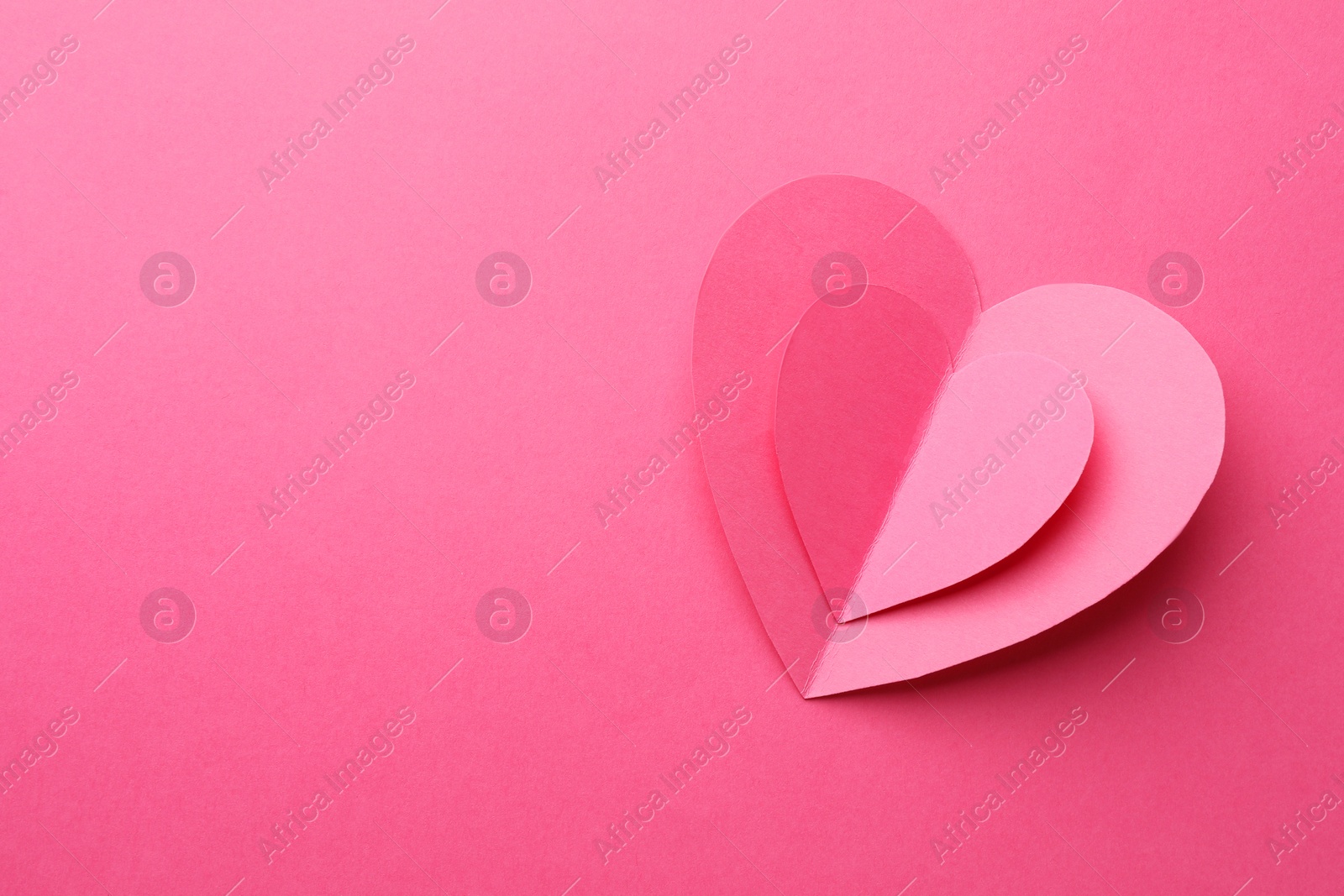 Photo of Paper hearts on pink background, top view. Space for text