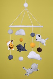 Photo of Cute baby crib mobile on yellow background