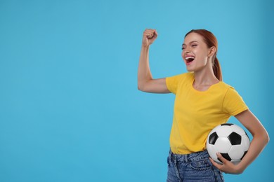 Photo of Emotional fan holding football ball and celebrating on light blue background, space for text