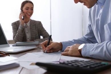Photo of Tax accountant working at table in office, closeup