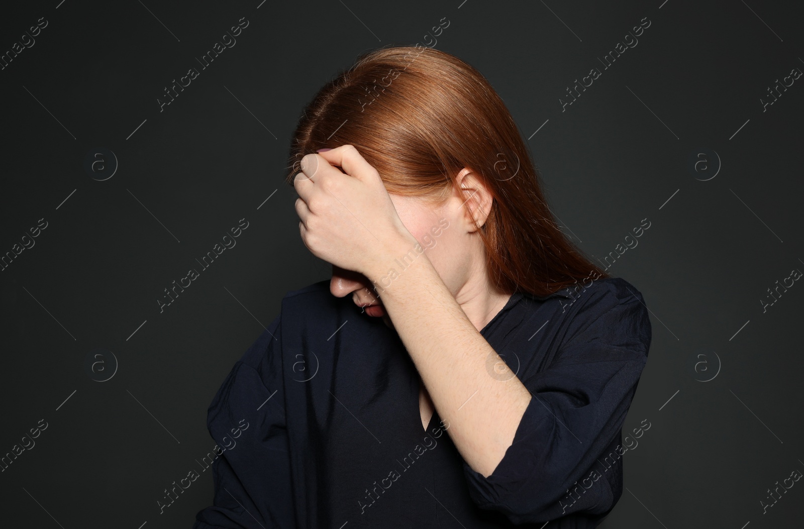 Photo of Upset young woman crying against dark background