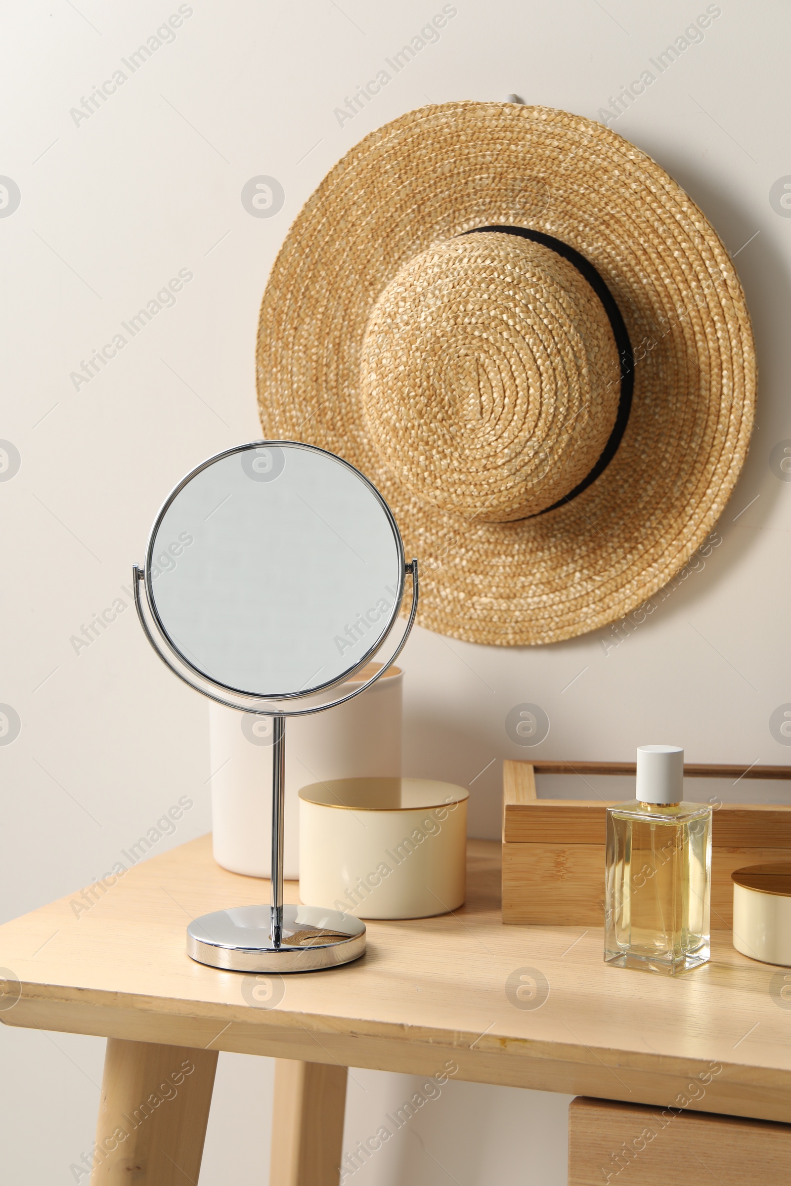 Photo of Mirror, perfume and accessories on makeup table in room