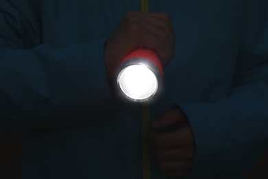 Photo of Man with bright flashlight in evening, closeup