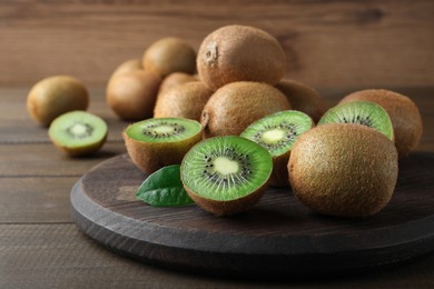 Cut and whole fresh ripe kiwis on wooden table