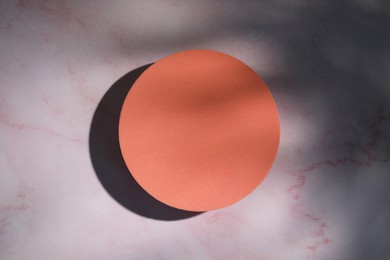 Photo of Orange circle on pink marble table, top view. Stylish presentation for product