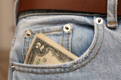 Photo of Dollar banknote in pocket of jeans, closeup. Spending money