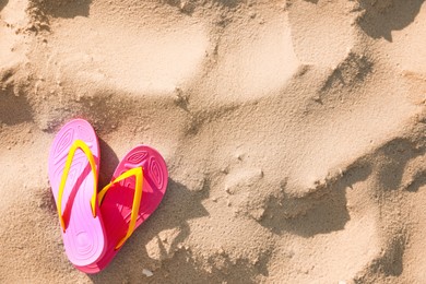 Photo of Stylish flip flops on beach, top view. Space for text