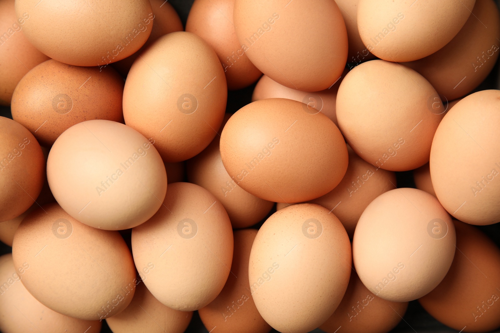 Photo of Pile of raw brown chicken eggs, top view