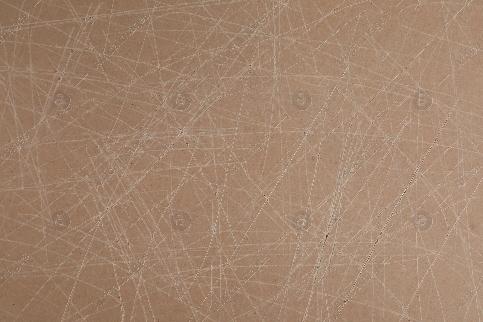 Photo of Old fiberboard with scratches as background, closeup