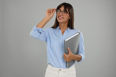 Photo of Happy secretary with folder on light grey background