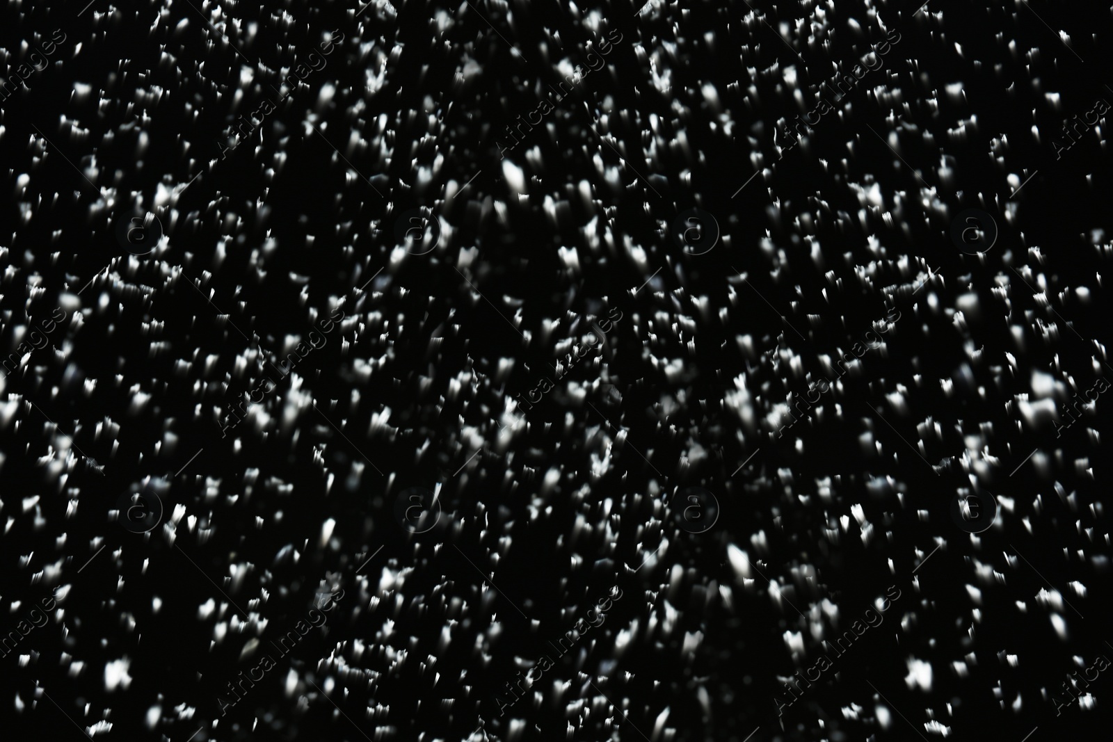 Photo of Snow flakes falling on black background. Winter weather