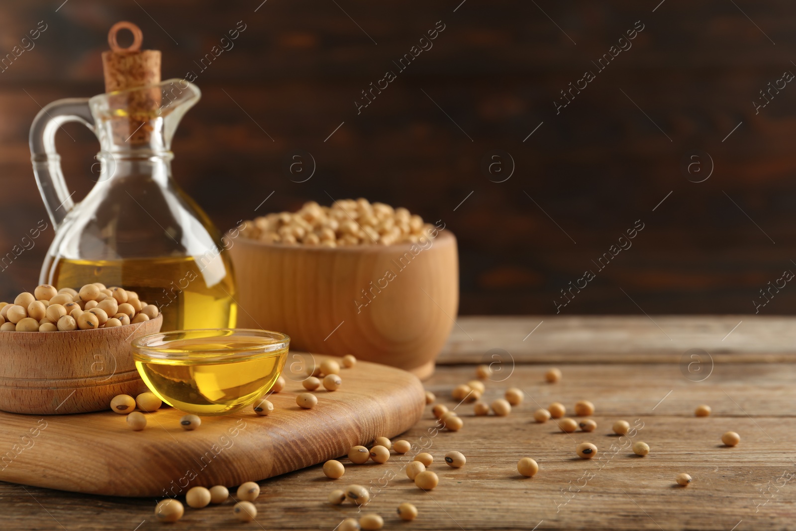 Photo of Composition with soybean oil on wooden table, space for text