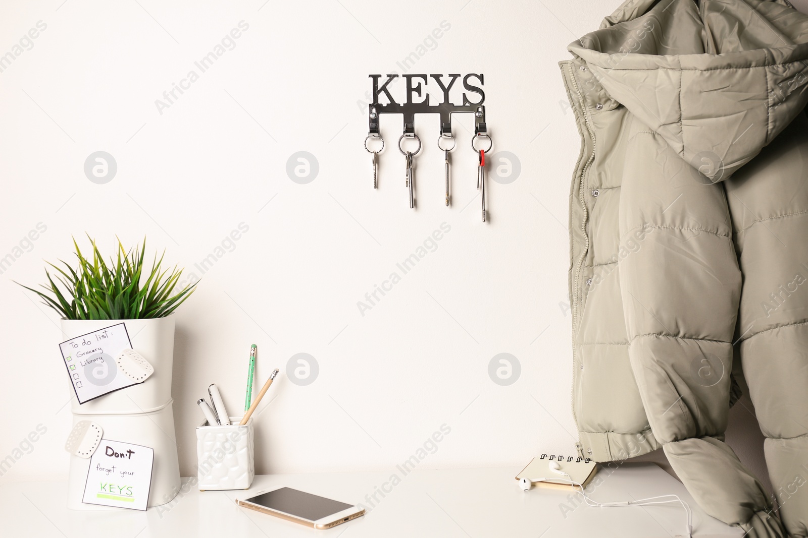 Photo of Metal key holder on light wall indoors