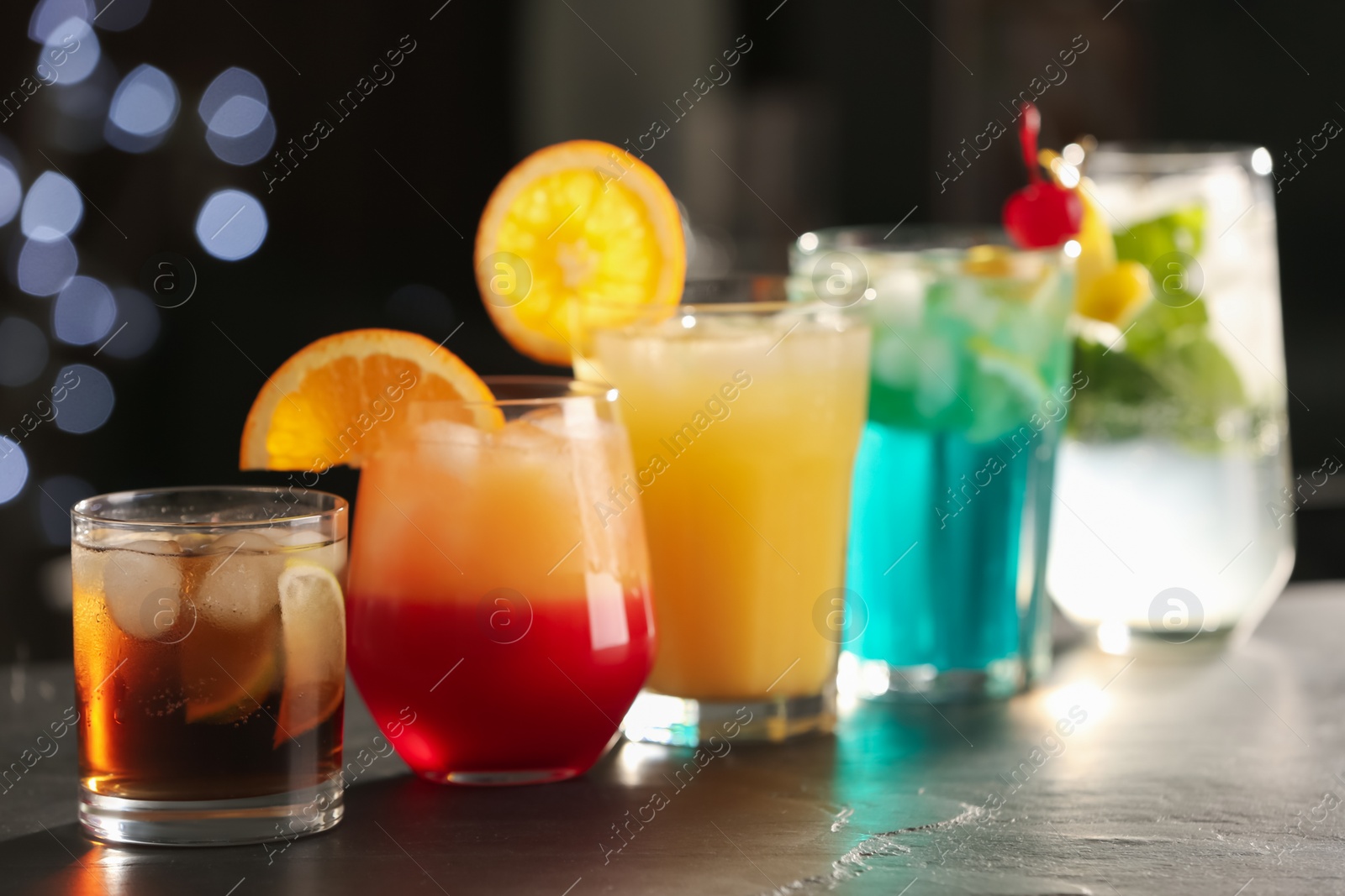 Photo of Different delicious cocktails on counter in bar