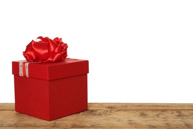 Red gift box with bow on wooden table against white background, space for text