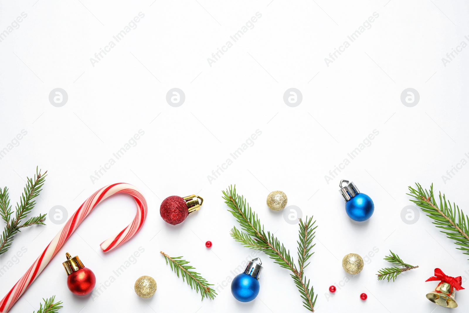 Photo of Flat lay composition with Christmas tree branches and festive decor on white background. Space for text