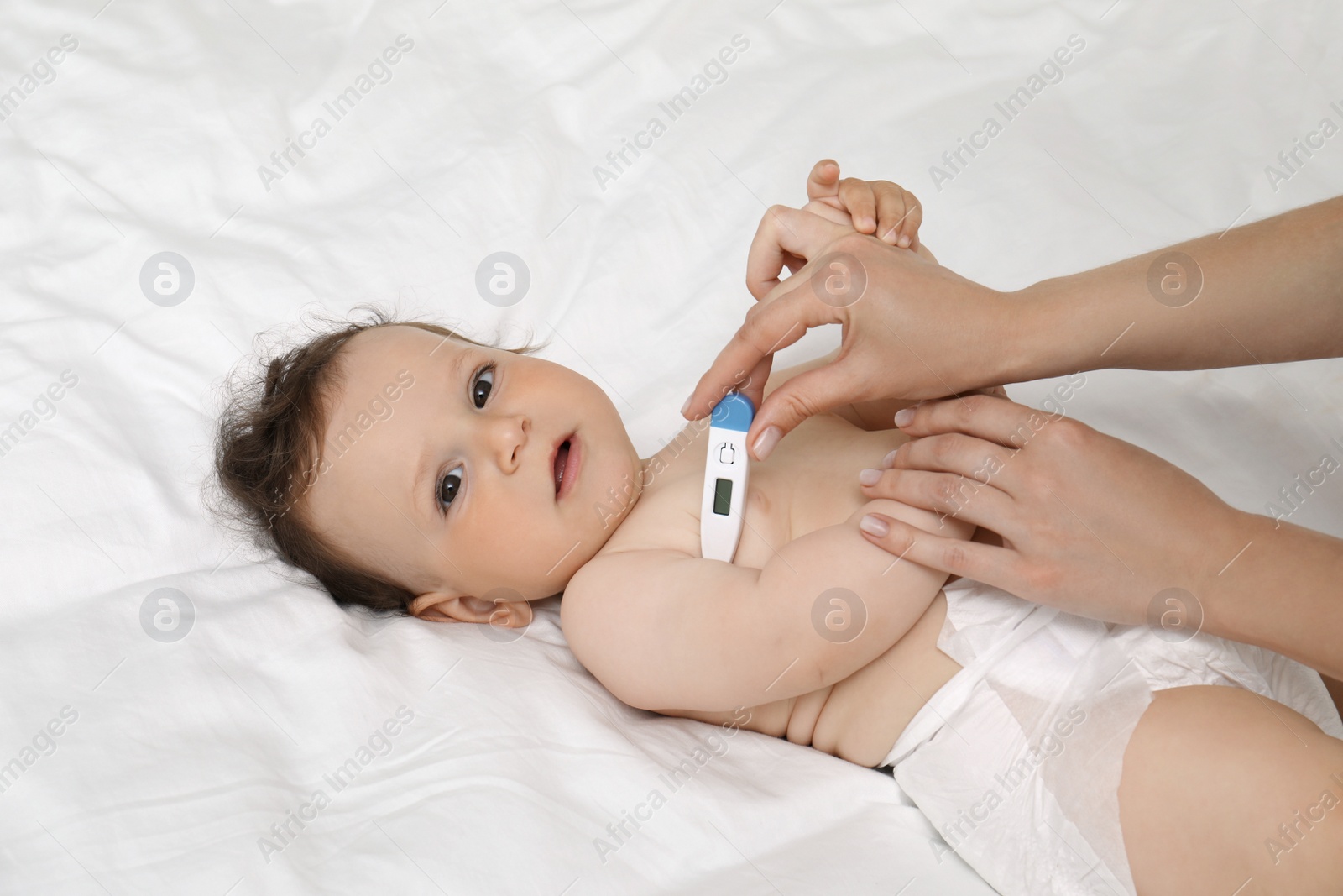 Photo of Mother measuring her baby's temperature, closeup. Health care