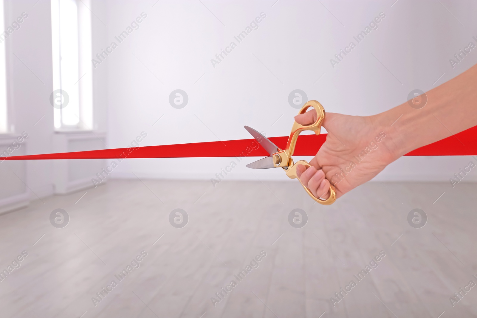 Photo of Woman cutting red ribbon on blurred background. Festive ceremony