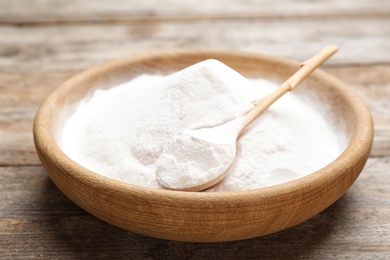 Plate with baking soda on wooden background