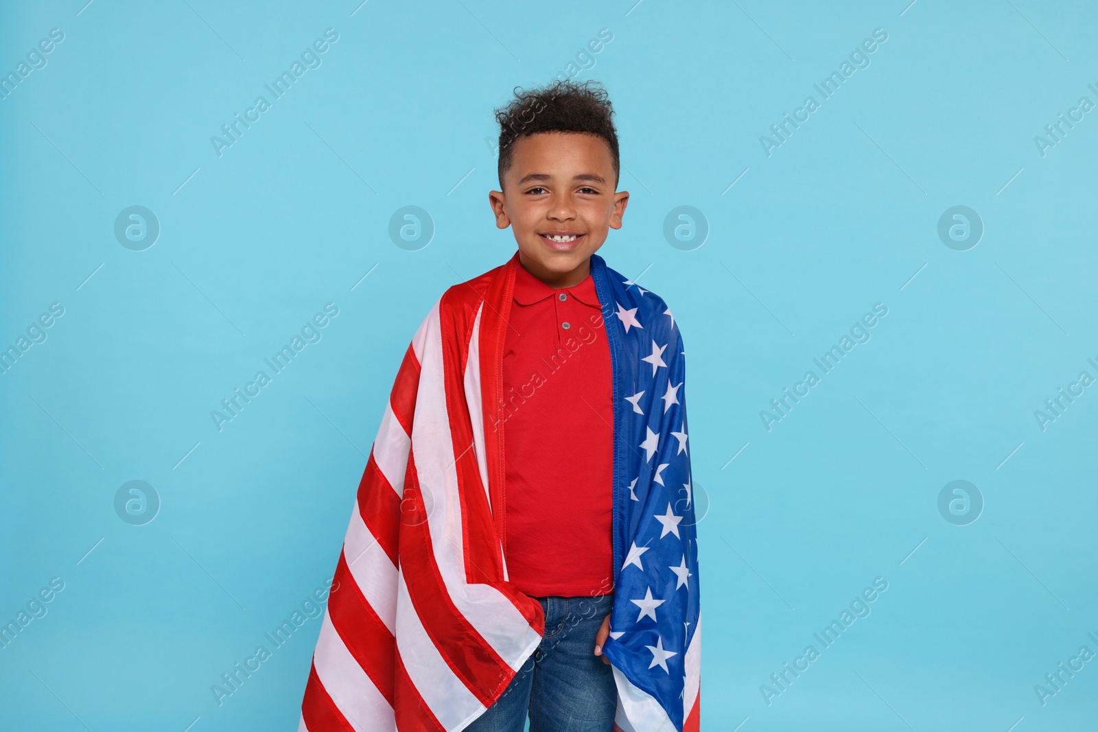 Photo of 4th of July - Independence Day of USA. Happy boy with American flag on light blue background