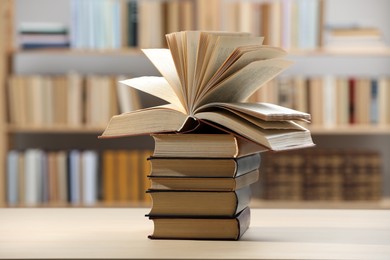Photo of Stack of books on wooden table in library