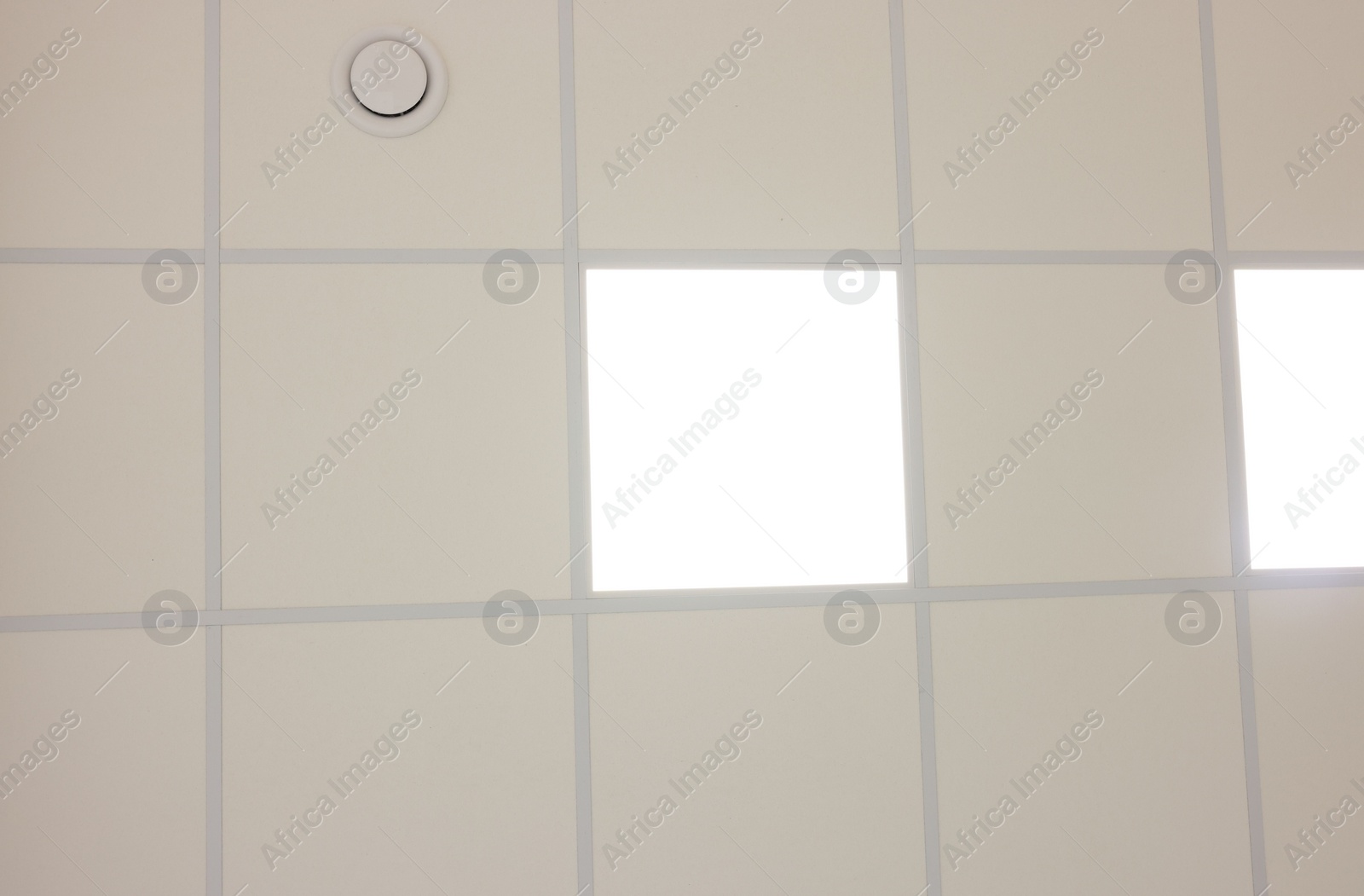 Photo of White ceiling with PVC tiles and lighting, bottom view