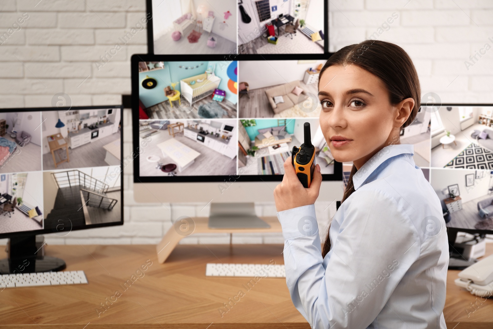 Photo of Female security guard with portable transmitter at workplace