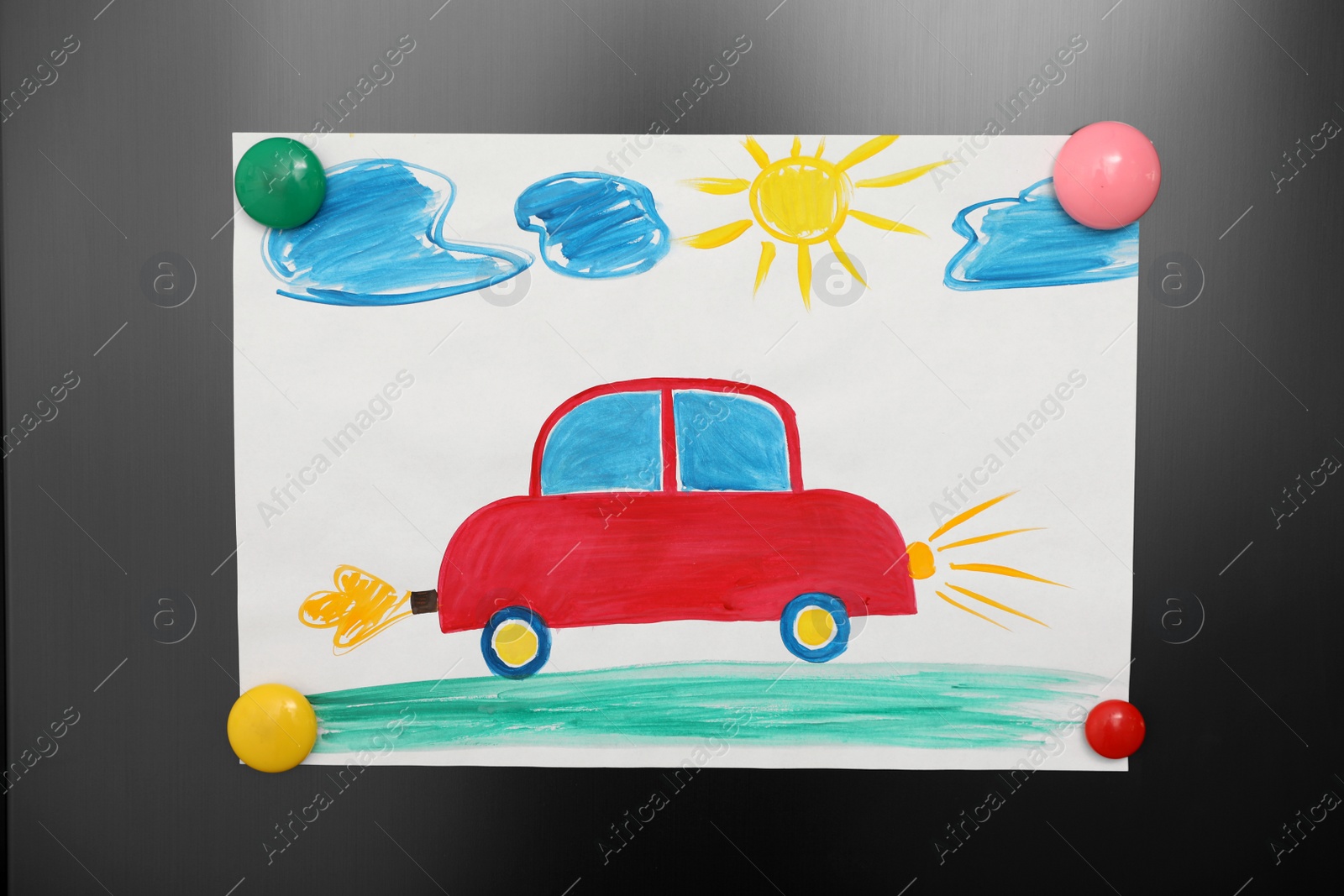 Photo of Adorable child's drawing with magnets on refrigerator  door, closeup