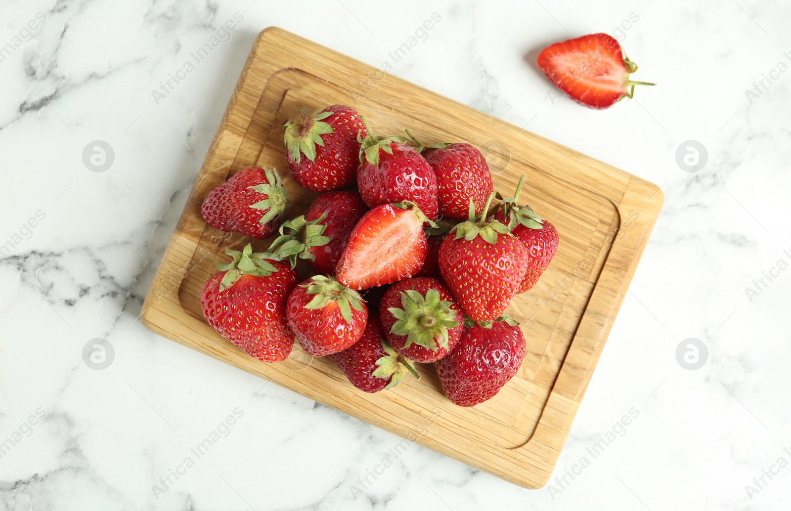 Photo of Delicious ripe strawberries on white marble table, flat lay