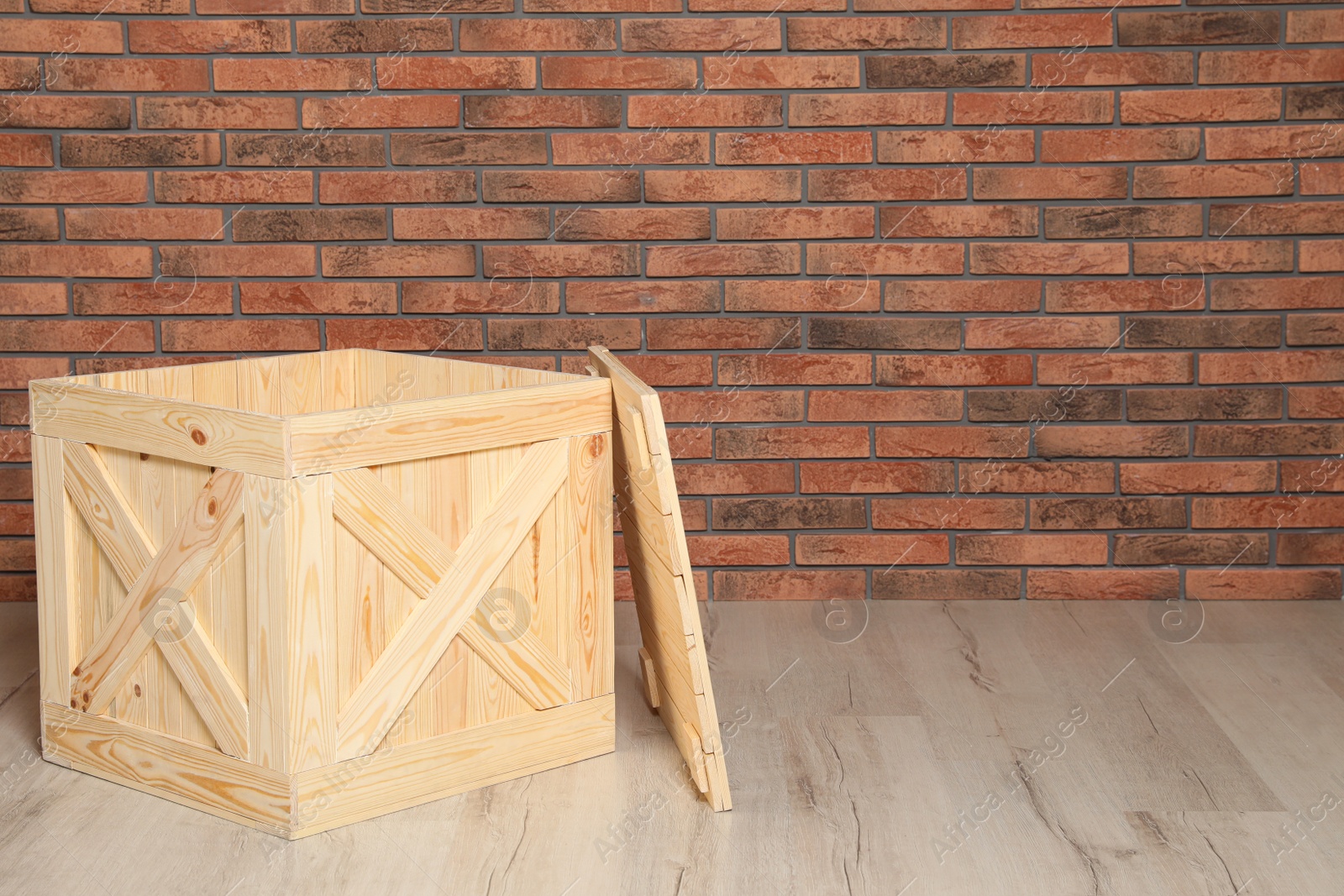 Photo of Wooden crate on floor at brick wall. Space for text