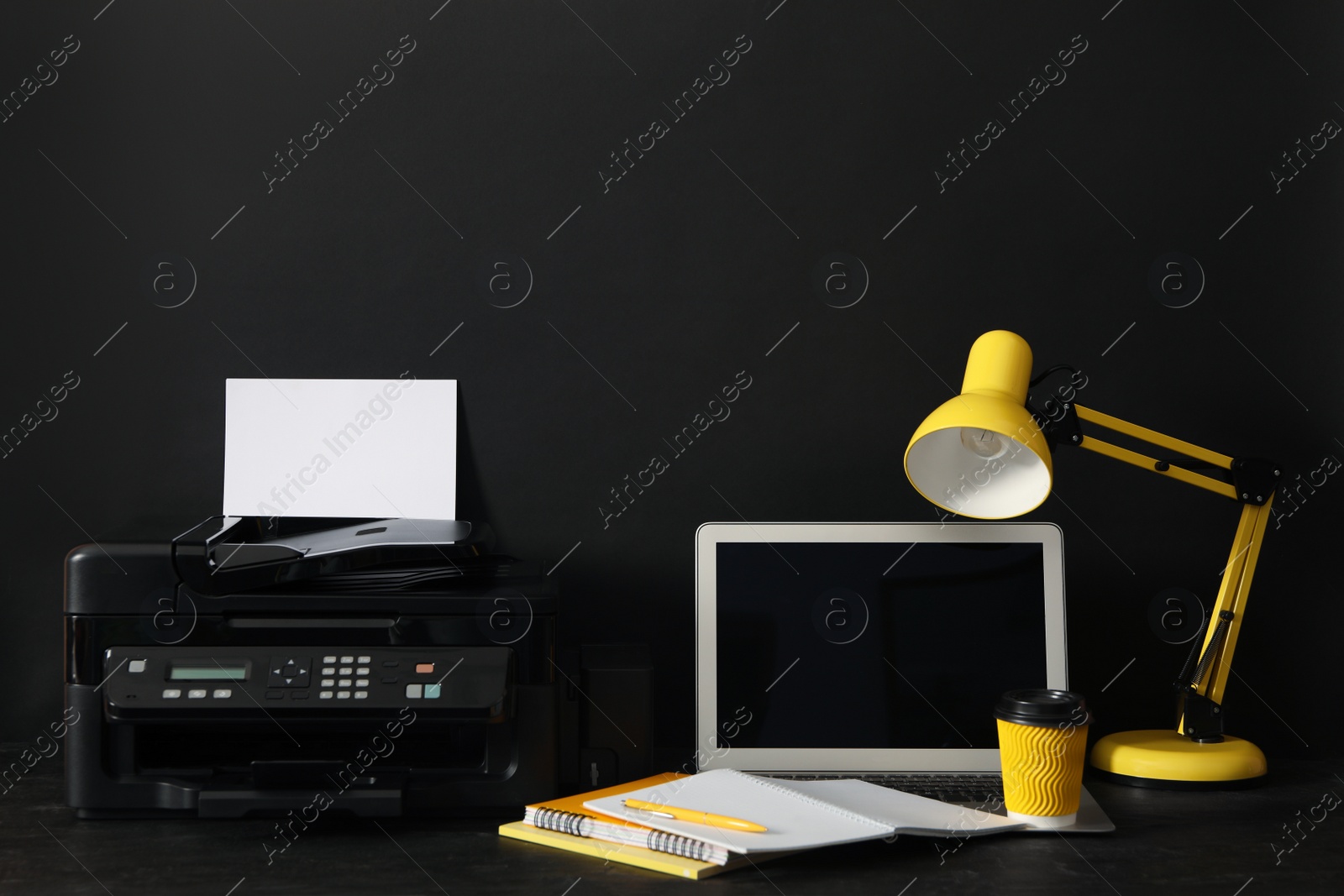 Photo of Modern printer, laptop and office supplies on black background