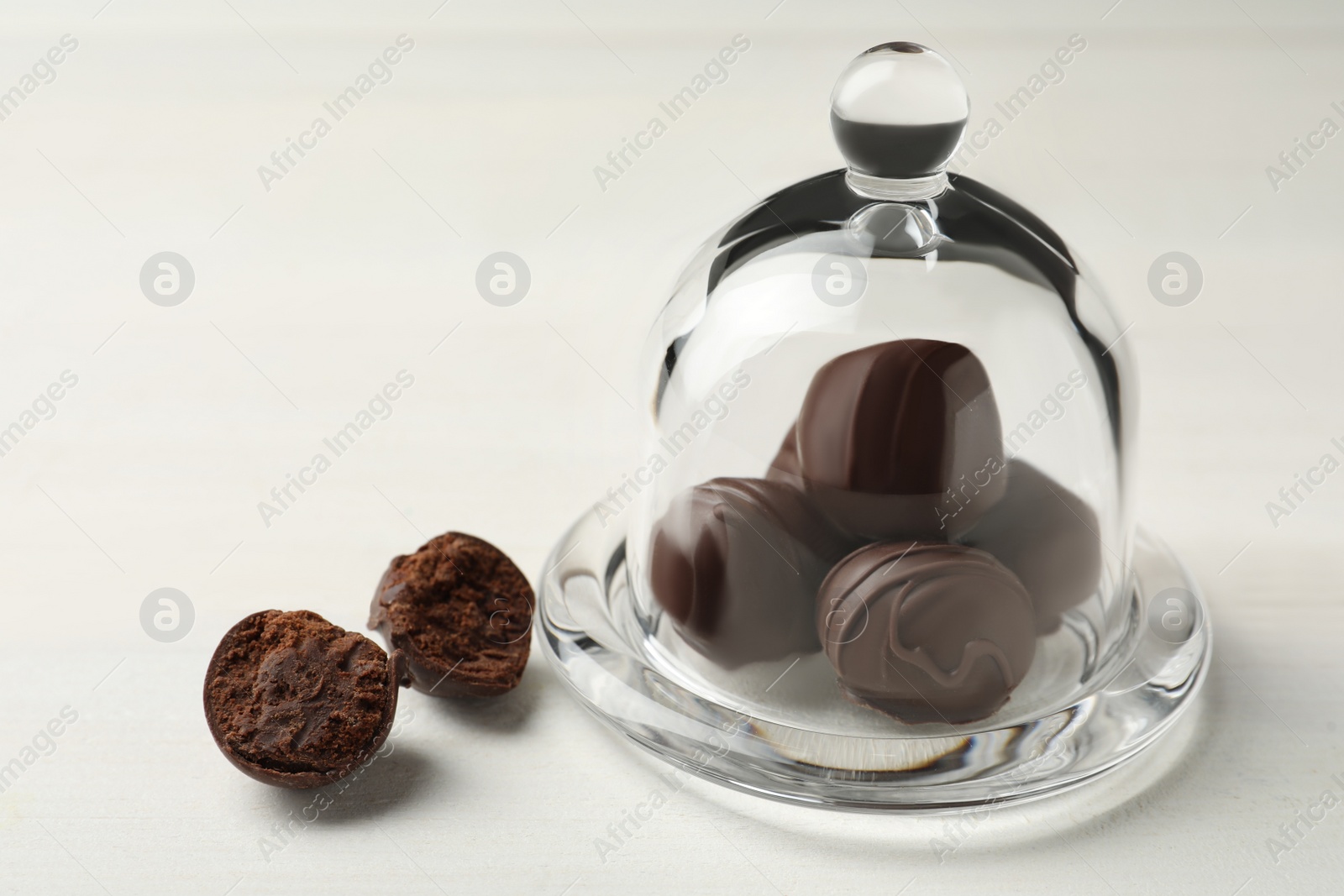 Photo of Many delicious chocolate truffles on white table