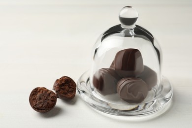 Many delicious chocolate truffles on white table