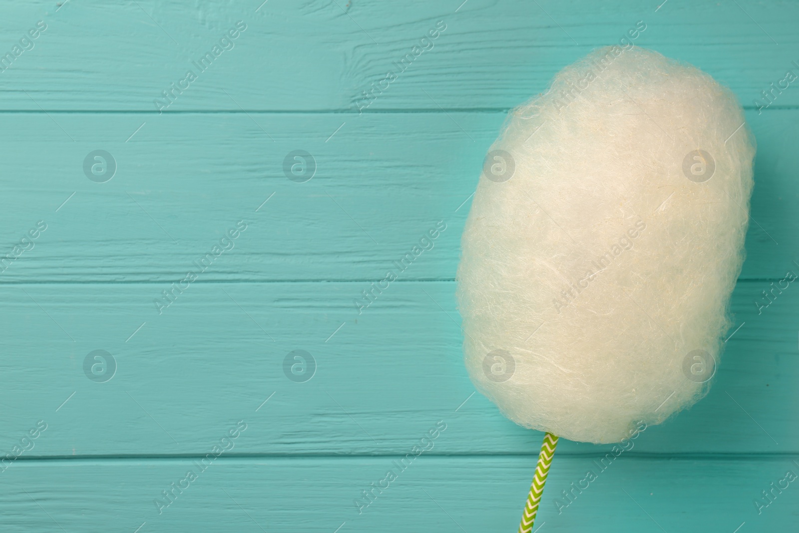 Photo of One sweet cotton candy on turquoise wooden table, top view. Space for text